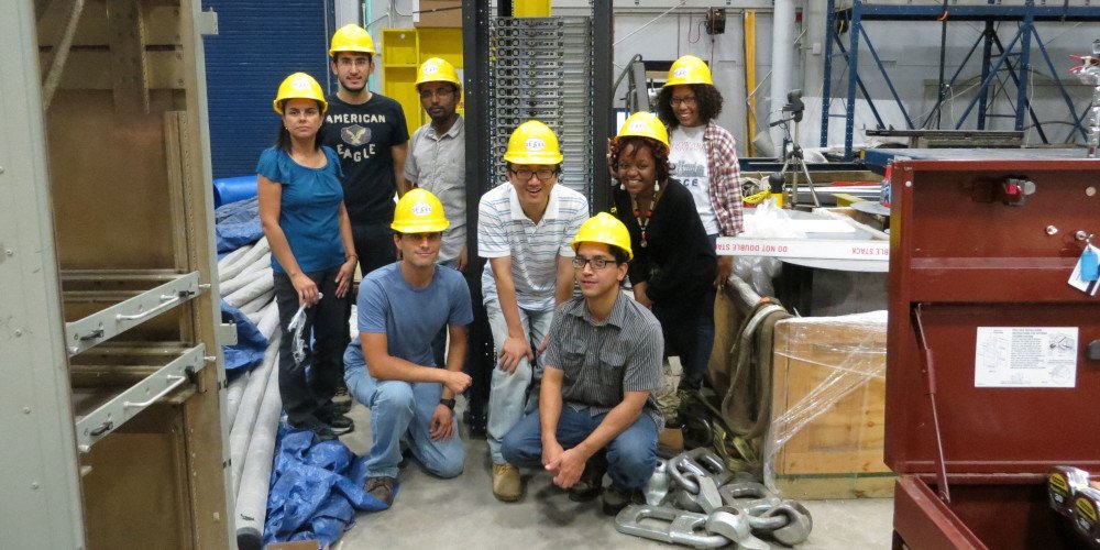 a group of men and women wearing hardhats in an industrial setting