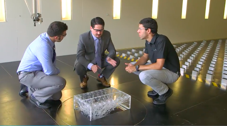 Discussing a scale model in UF's Terraformer wind tunnel.